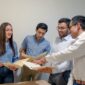 A Group of people looking at papers in the office during working hours